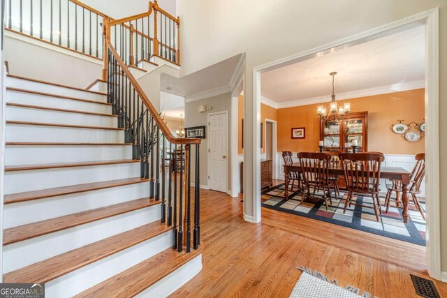 1461 Radstone Dr, Lawrenceville, GA 30044 - staircase with wood finished floors, a chandelier, ornamental molding, and a high ceiling