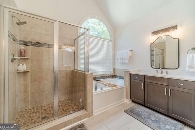 1461 Radstone Dr, Lawrenceville, GA 30044 - bathroom with vanity, vaulted ceiling, a bath, a stall shower, and tile patterned flooring