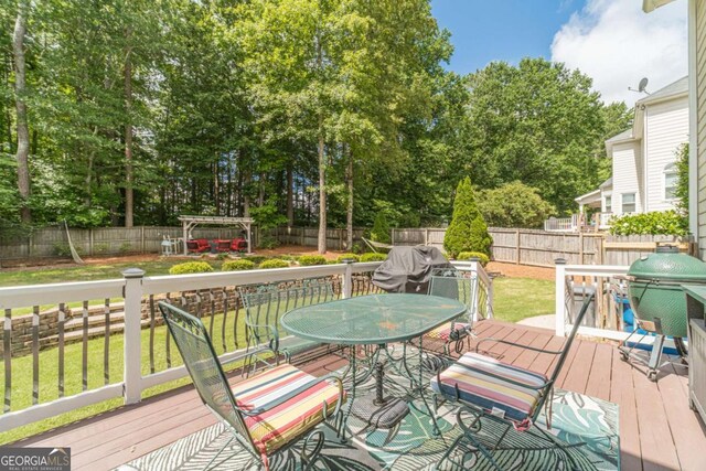 1461 Radstone Dr, Lawrenceville, GA 30044 - deck featuring a fenced backyard, outdoor dining space, and view of wooded area
