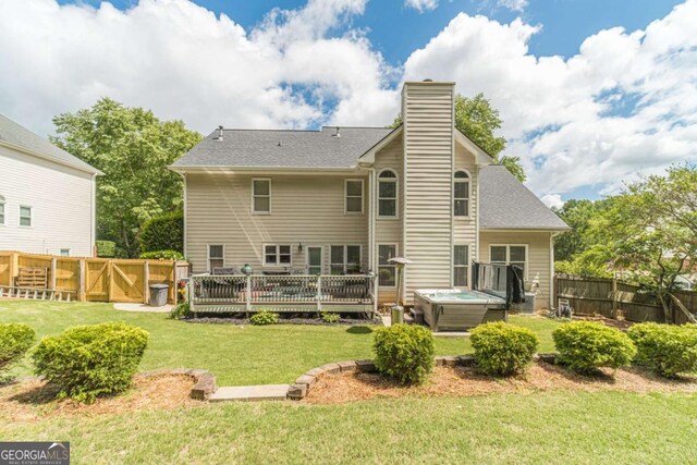 1461 Radstone Dr, Lawrenceville, GA 30044 - back of property featuring a hot tub, a fenced backyard, a deck, and a chimney