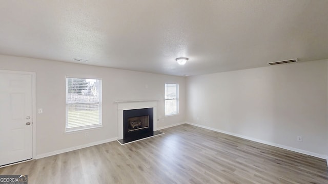 1001 Balsam Wood Trl, Villa Rica, GA 30180 - unfurnished living room featuring wood finished floors, a fireplace, and a textured ceiling