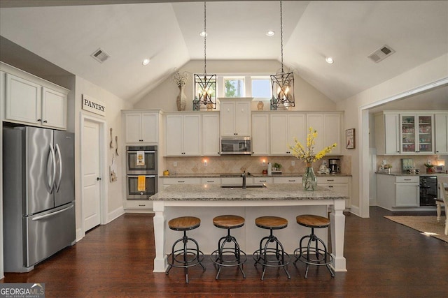 112 Sterling Lake Way, Jefferson, GA 30549 - kitchen with stainless steel appliances, lofted ceiling, a breakfast bar area, dark wood-style floors, and light stone counters