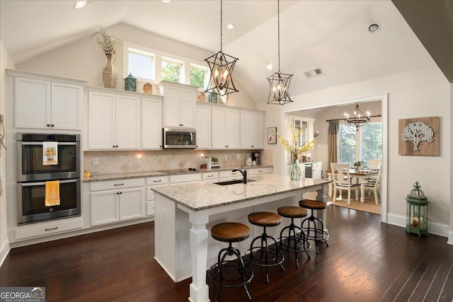 112 Sterling Lake Way, Jefferson, GA 30549 - kitchen with appliances with stainless steel finishes, white cabinetry, dark wood finished floors, high vaulted ceiling, and light stone counters