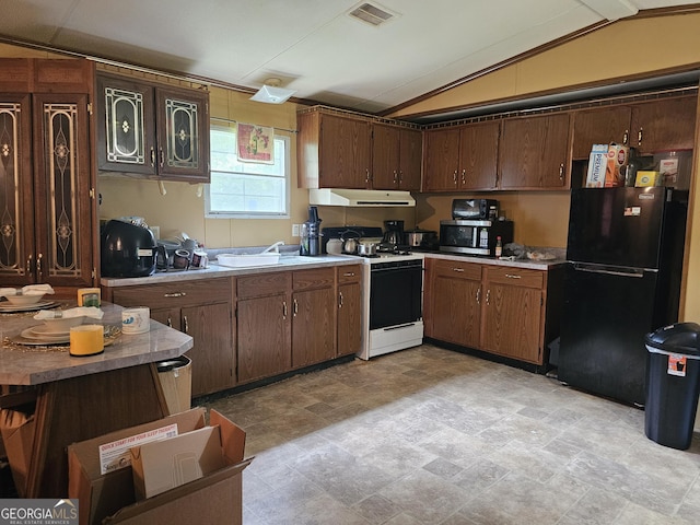 74 Holly Dr, Carrollton, GA 30116 - kitchen featuring freestanding refrigerator, white gas range oven, under cabinet range hood, vaulted ceiling, and stainless steel microwave