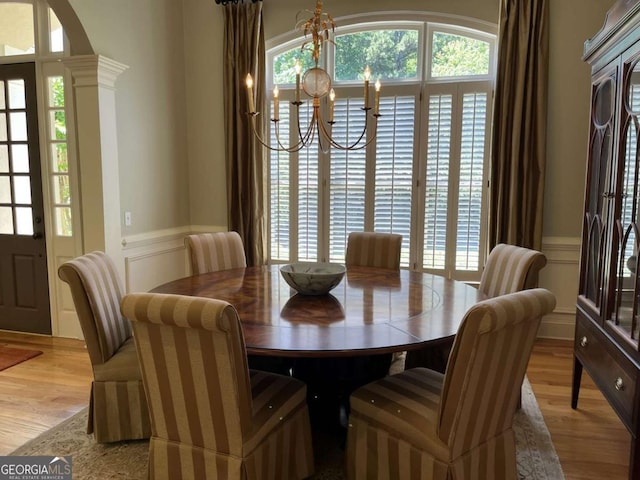 605 Meadows Creek Dr, Johns Creek, GA 30005 - dining room featuring a chandelier, a wainscoted wall, light wood finished floors, and a decorative wall