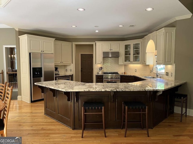 605 Meadows Creek Dr, Johns Creek, GA 30005 - kitchen with appliances with stainless steel finishes, under cabinet range hood, crown molding, a peninsula, and light stone counters