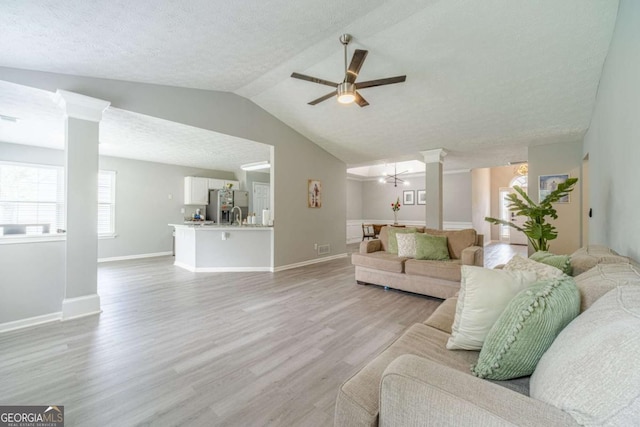 2895 Dominion Walk Ln, Snellville, GA 30078 - living area featuring decorative columns, a ceiling fan, light wood-style flooring, vaulted ceiling, and a textured ceiling