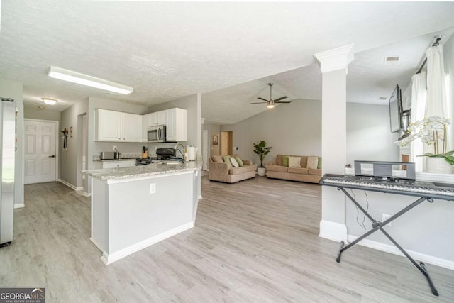2895 Dominion Walk Ln, Snellville, GA 30078 - kitchen featuring stainless steel microwave, light wood-type flooring, white cabinets, a peninsula, and a ceiling fan