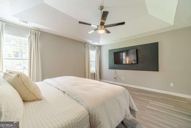 2895 Dominion Walk Ln, Snellville, GA 30078 - bedroom with wood finished floors, a ceiling fan, and a raised ceiling