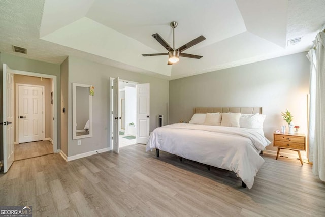 2895 Dominion Walk Ln, Snellville, GA 30078 - bedroom with light wood-style floors, a tray ceiling, and a ceiling fan