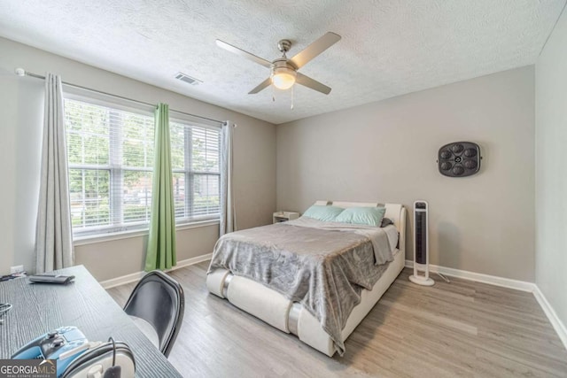2895 Dominion Walk Ln, Snellville, GA 30078 - bedroom with light wood-style flooring, a textured ceiling, an office area, and a ceiling fan