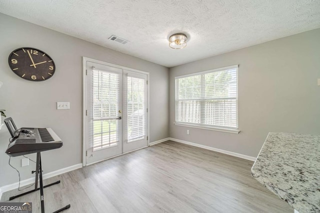 2895 Dominion Walk Ln, Snellville, GA 30078 - unfurnished dining area featuring french doors, wood finished floors, and a textured ceiling