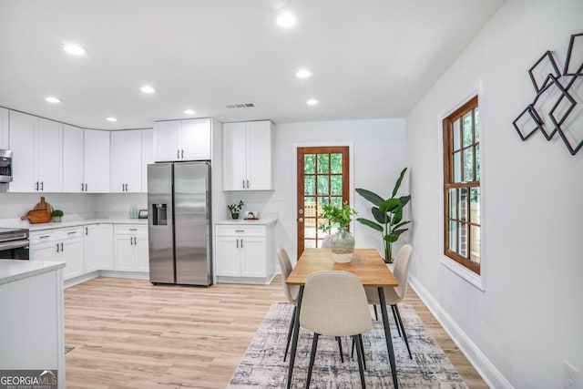 911 Oakland Dr SW, Atlanta, GA 30310 - kitchen with stainless steel appliances, light wood-style flooring, light countertops, recessed lighting, and white cabinetry