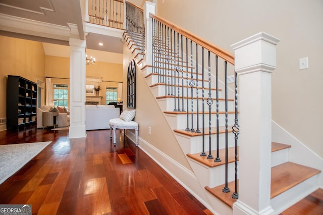 713 Birkdale Blvd, Carrollton, GA 30116 - stairway featuring wood finished floors, a high ceiling, ornate columns, and a fireplace