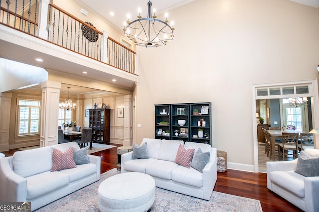 713 Birkdale Blvd, Carrollton, GA 30116 - living area with a chandelier, wood finished floors, a towering ceiling, ornamental molding, and decorative columns
