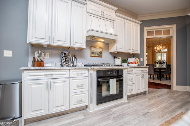 713 Birkdale Blvd, Carrollton, GA 30116 - kitchen with oven, a chandelier, crown molding, light wood-style floors, and light stone countertops