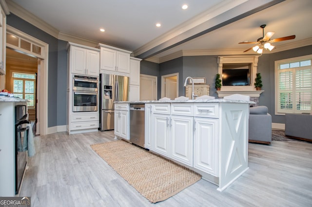 713 Birkdale Blvd, Carrollton, GA 30116 - kitchen featuring appliances with stainless steel finishes, crown molding, open floor plan, white cabinets, and a center island with sink