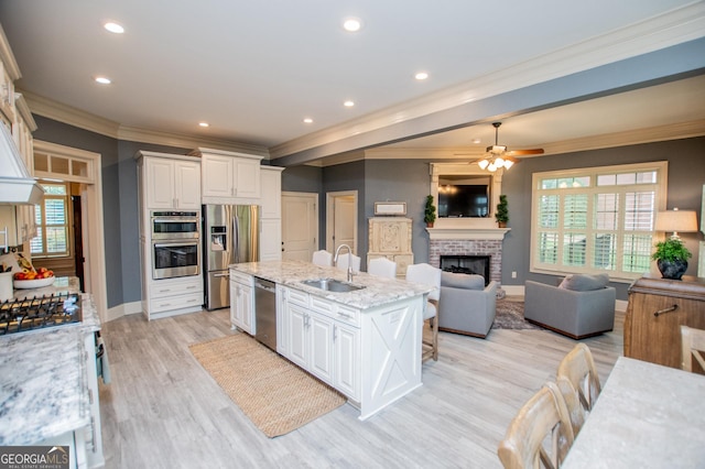 713 Birkdale Blvd, Carrollton, GA 30116 - kitchen with stainless steel appliances, open floor plan, ornamental molding, white cabinets, and a brick fireplace