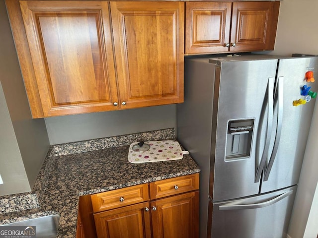 2479 Peachtree Rd NE Unit 1714, Atlanta, GA 30305 - kitchen with stainless steel fridge with ice dispenser, brown cabinetry, and dark stone countertops