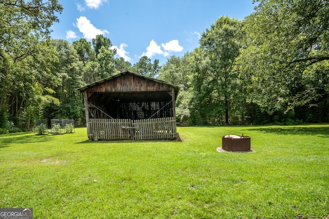 67 Dixie Park Rd NW, Rome, GA 30165 - view of green lawn featuring an outbuilding, a fire pit, an outdoor structure, and a view of trees
