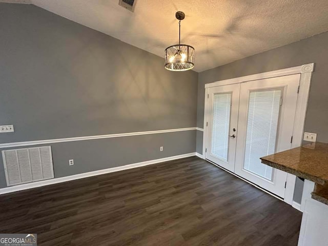 160 Lake Wellington Dr, Kingsland, GA 31548 - unfurnished dining area featuring french doors, dark wood-type flooring, a chandelier, and a textured ceiling