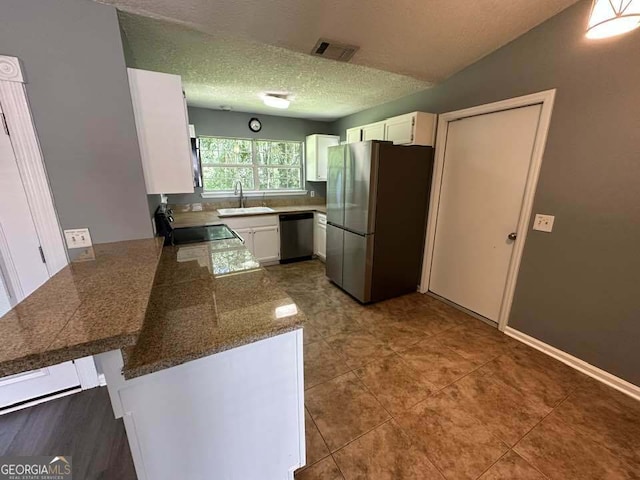 160 Lake Wellington Dr, Kingsland, GA 31548 - kitchen featuring stainless steel appliances, a peninsula, white cabinetry, tile counters, and tile patterned flooring