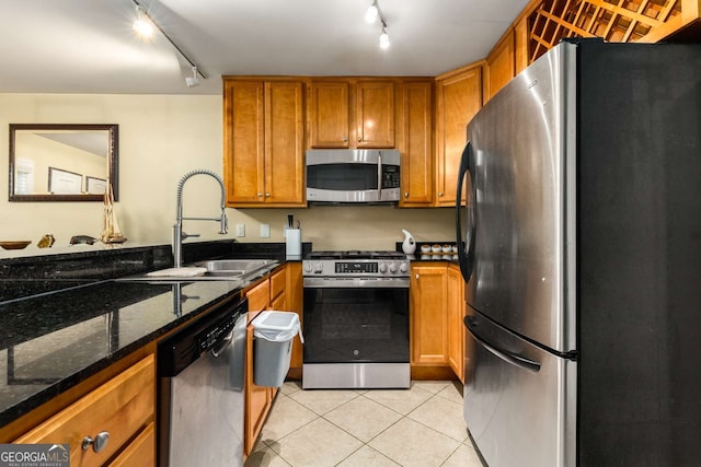 1445 Monroe Dr Unit 14B, Atlanta, GA 30324 - kitchen with stainless steel appliances, rail lighting, brown cabinets, and light tile patterned floors