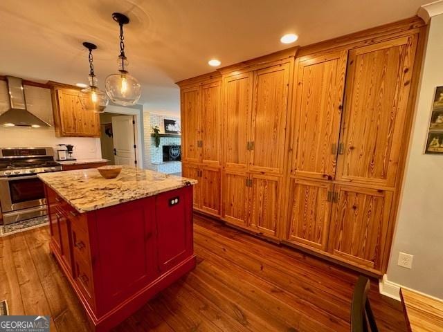 360 Morgan Mill Rd, Brooks, GA 30205 - kitchen featuring stainless steel range with gas stovetop, a center island, dark wood-type flooring, extractor fan, and decorative light fixtures