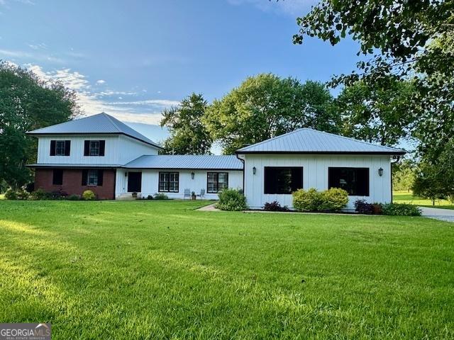360 Morgan Mill Rd, Brooks, GA 30205 - modern farmhouse style home featuring a front yard and a metal roof
