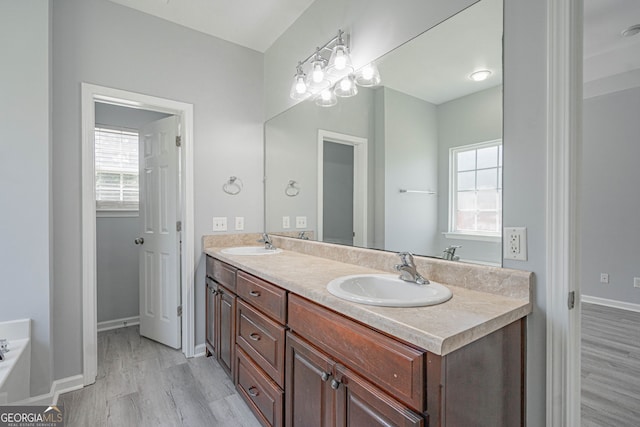 231 Cyane Ln, Guyton, GA 31312 - full bathroom featuring double vanity, healthy amount of natural light, wood finished floors, and a bath