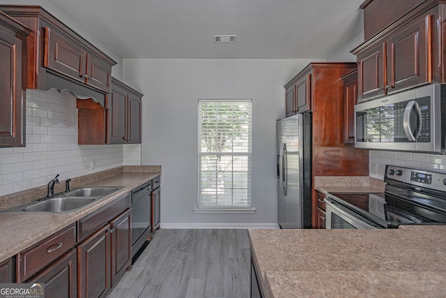 231 Cyane Ln, Guyton, GA 31312 - kitchen with stainless steel appliances, light wood finished floors, decorative backsplash, and light countertops