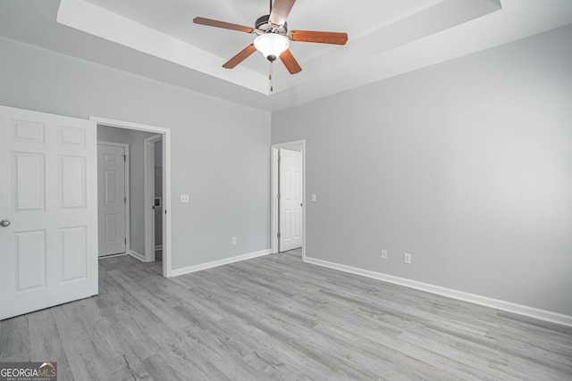 231 Cyane Ln, Guyton, GA 31312 - unfurnished bedroom featuring a raised ceiling, light wood-type flooring, and a ceiling fan
