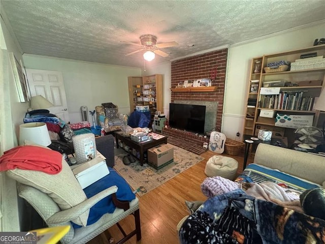 713 Pine Chase, Lawrenceville, GA 30043 - living room featuring a textured ceiling, a ceiling fan, wood finished floors, and a brick fireplace