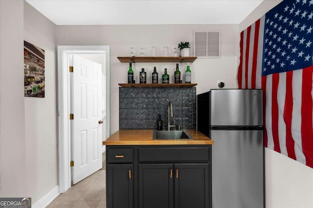2653 W Main St NW, Atlanta, GA 30318 - kitchen featuring freestanding refrigerator, light tile patterned flooring, open shelves, and wooden counters
