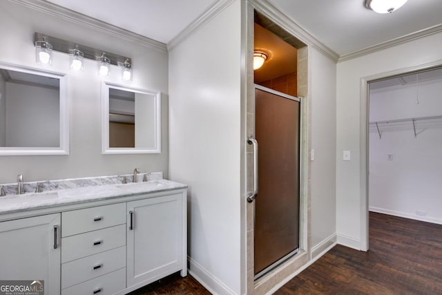 370 Simms Rd, Carrollton, GA 30117 - bathroom featuring crown molding, wood finished floors, a stall shower, double vanity, and a spacious closet