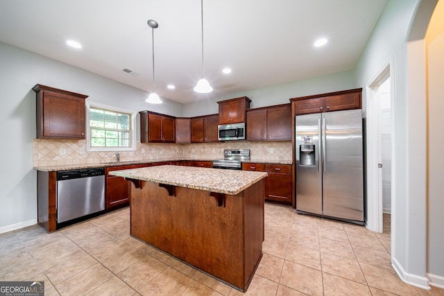 38 Pin Oak Way, Hamilton, GA 31811 - kitchen with stainless steel appliances, decorative backsplash, light stone counters, a kitchen island, and a breakfast bar area