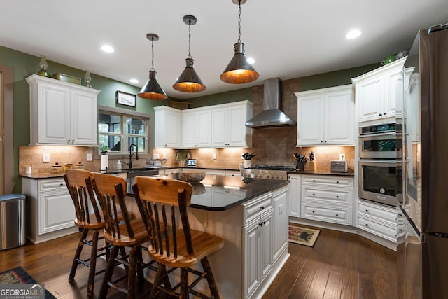 4 Bluff Ct SE, Cartersville, GA 30120 - kitchen featuring wall chimney range hood, dark countertops, appliances with stainless steel finishes, white cabinets, and recessed lighting