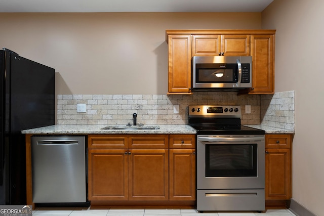 4 Bluff Ct SE, Cartersville, GA 30120 - kitchen with appliances with stainless steel finishes, brown cabinets, light stone counters, and decorative backsplash