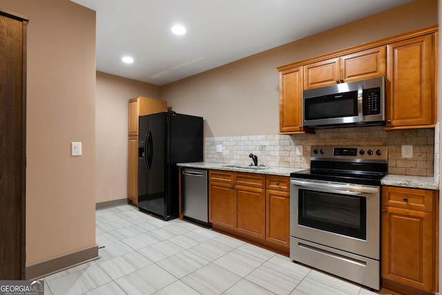 4 Bluff Ct SE, Cartersville, GA 30120 - kitchen featuring stainless steel appliances, decorative backsplash, brown cabinets, light stone countertops, and light tile patterned flooring