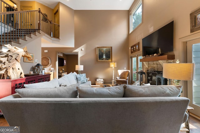4 Bluff Ct SE, Cartersville, GA 30120 - living room with a towering ceiling, healthy amount of natural light, wood finished floors, stairway, and a stone fireplace