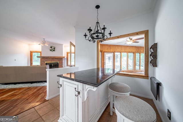 124 Old Salem Trl, Pine Mountain, GA 31822 - kitchen featuring ceiling fan, open floor plan, a fireplace, a center island, and crown molding