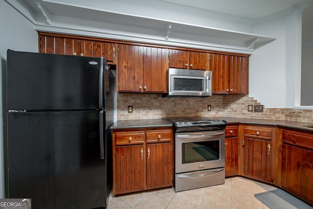 124 Old Salem Trl, Pine Mountain, GA 31822 - kitchen with stainless steel appliances, dark countertops, decorative backsplash, brown cabinetry, and ornamental molding