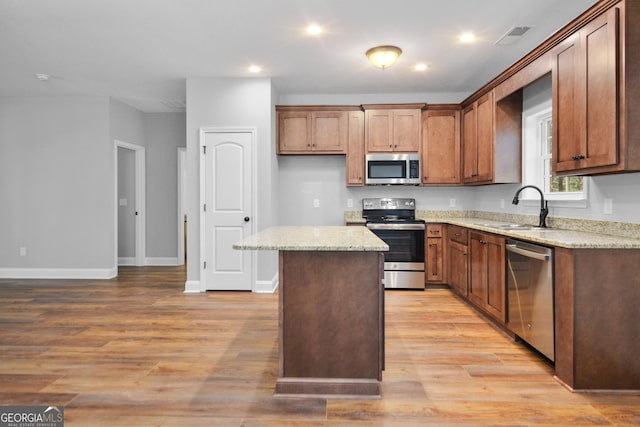 3177 Rodgers Creek Rd Unit 169, Ellijay, GA 30540 - kitchen featuring appliances with stainless steel finishes, a kitchen island, light wood-style floors, light stone countertops, and recessed lighting