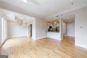 2255 Peachtree Rd NE Unit 620, Atlanta, GA 30309 - unfurnished living room featuring ornamental molding and wood finished floors
