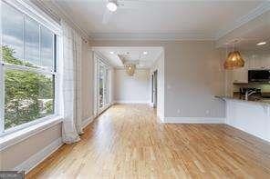 2255 Peachtree Rd NE Unit 620, Atlanta, GA 30309 - unfurnished living room featuring crown molding and wood finished floors