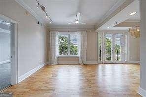 2255 Peachtree Rd NE Unit 620, Atlanta, GA 30309 - empty room featuring crown molding, a ceiling fan, a chandelier, and wood finished floors
