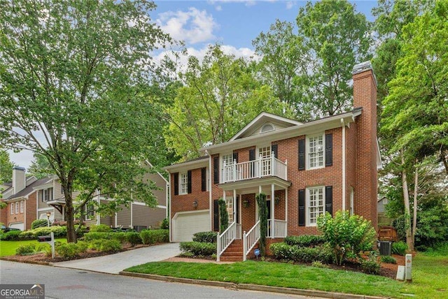 1117 Haven Glen Ln NE, Brookhaven, GA 30319 - colonial house featuring a balcony, concrete driveway, brick siding, a chimney, and an attached garage