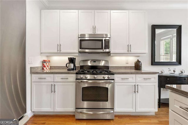 1117 Haven Glen Ln NE, Brookhaven, GA 30319 - kitchen featuring stainless steel appliances, dark stone counters, white cabinetry, light wood finished floors, and crown molding