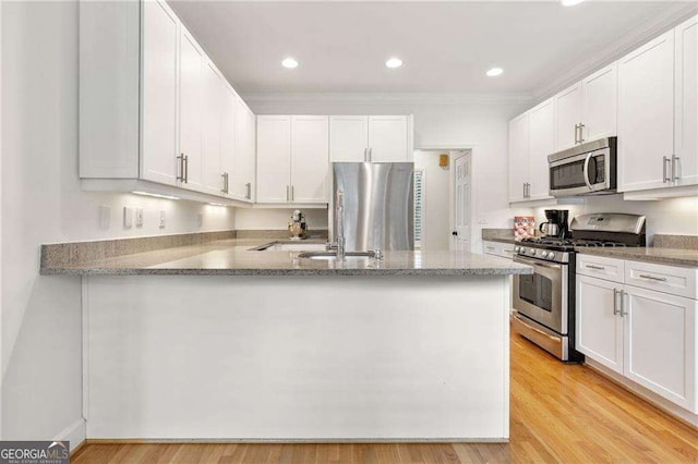 1117 Haven Glen Ln NE, Brookhaven, GA 30319 - kitchen featuring stainless steel appliances, light stone counters, a peninsula, white cabinetry, and recessed lighting