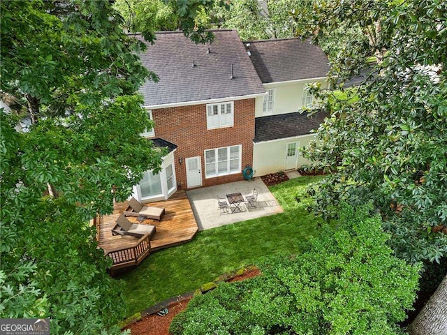 1117 Haven Glen Ln NE, Brookhaven, GA 30319 - rear view of house with a shingled roof, brick siding, a wooden deck, a yard, and a patio